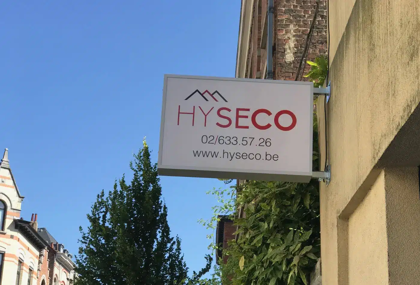 Enseigne Hyseco à l’entrée de nos bureaux à Bruxelles, spécialiste en adaptation de salle de bain AVIQ en Wallonie