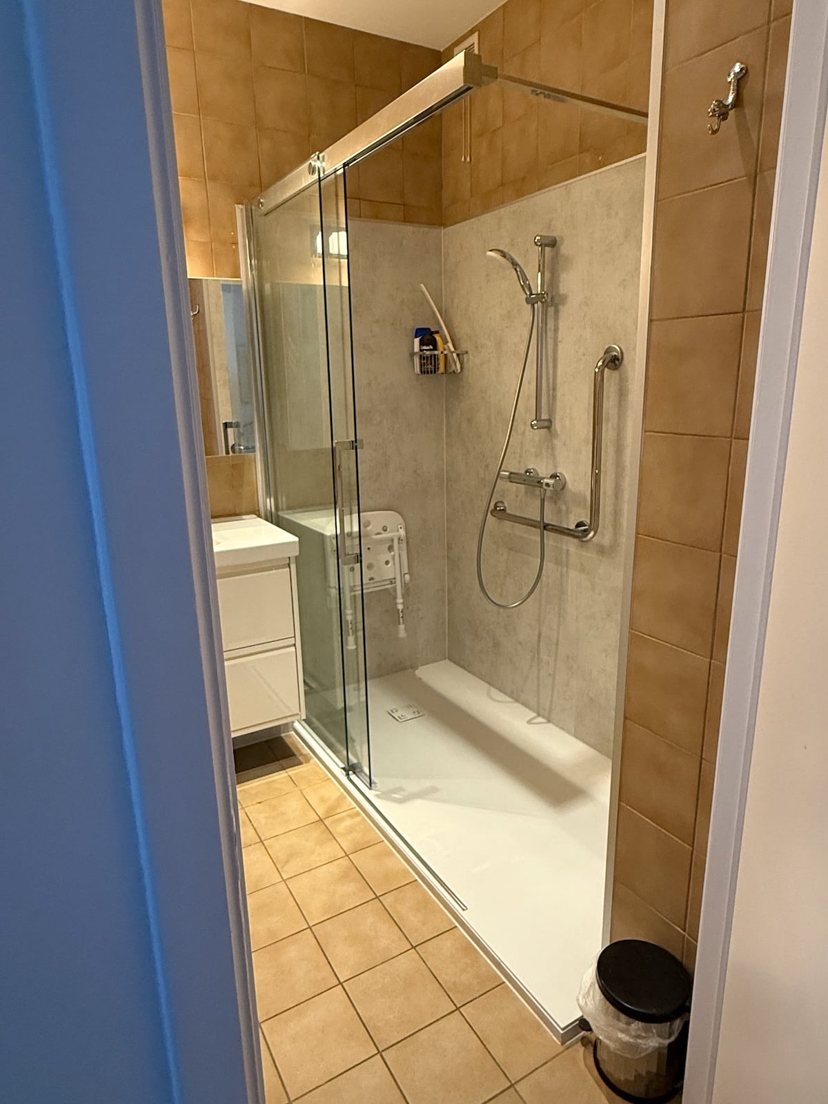 Douche PMR installée à Bruxelles avec receveur extra-plat et paroi en verre