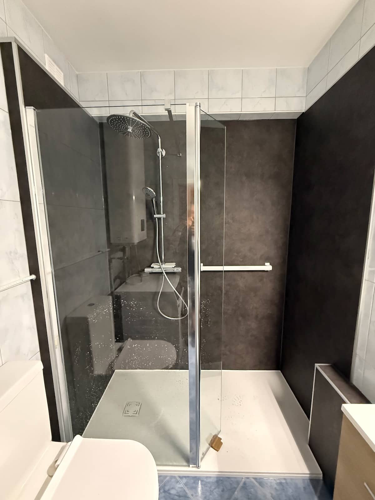 Douche PMR avec paroi en verre et receveur extra-plat installée par Hyseco à Liège