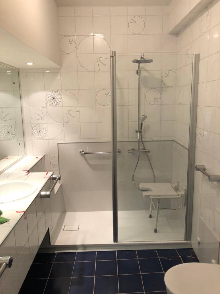 Douche PMR avec siège rabattable et barres d’appui installée par Hyseco à Namur
