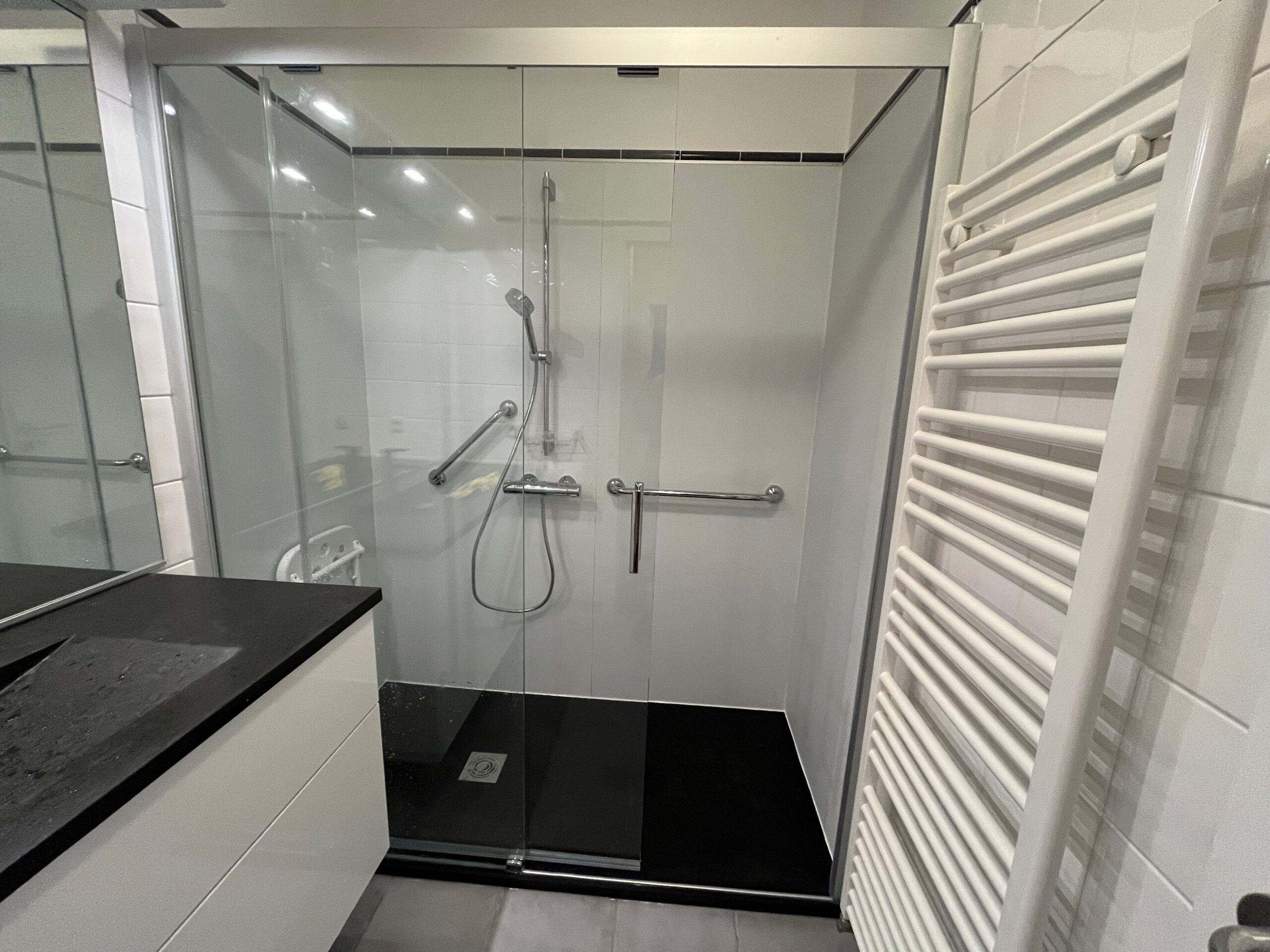 Douche senior accessible installée à Bruxelles avec barres d'appui et receveur extra-plat