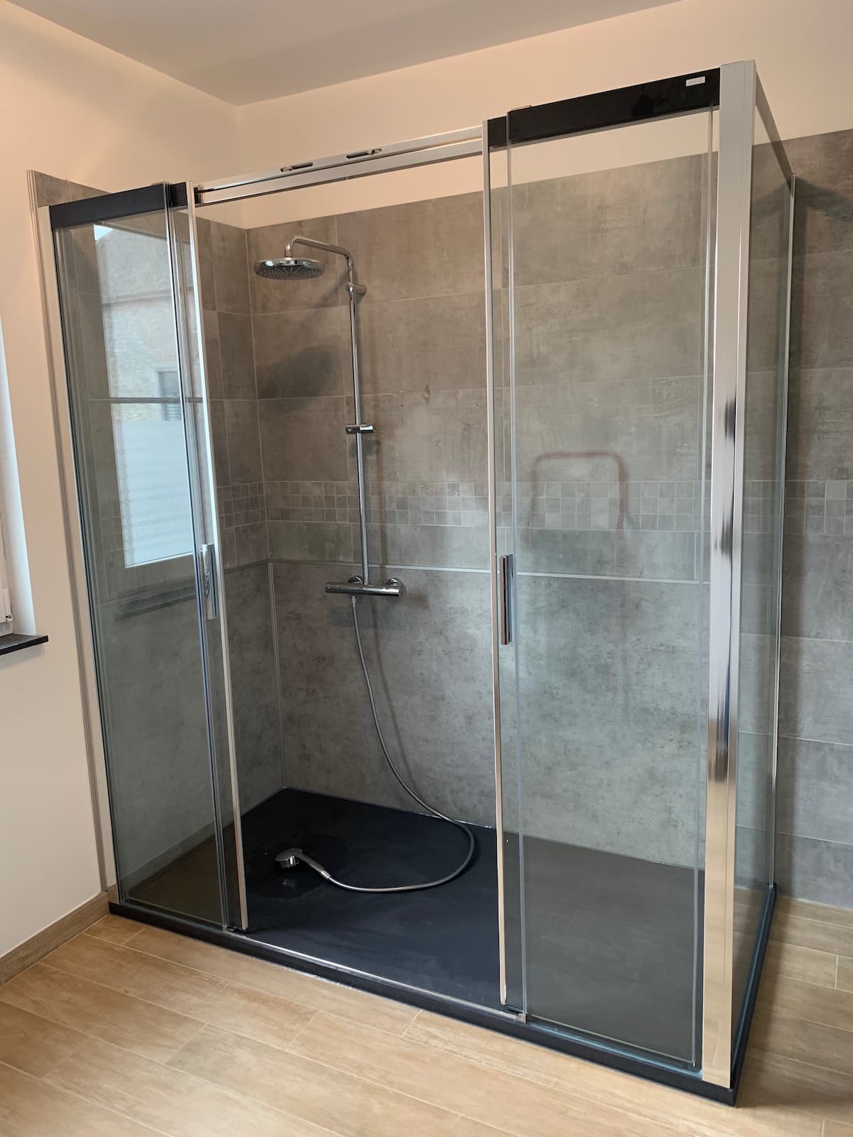 Grande douche accessible avec receveur extra-plat et parois vitrées coulissantes installée dans le Hainaut